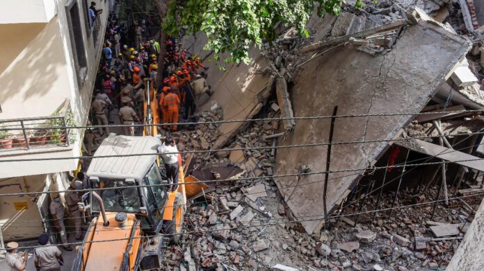 Rescue workers conduct operations after a five-storey building collapsed in Satya Niketan, Delhi